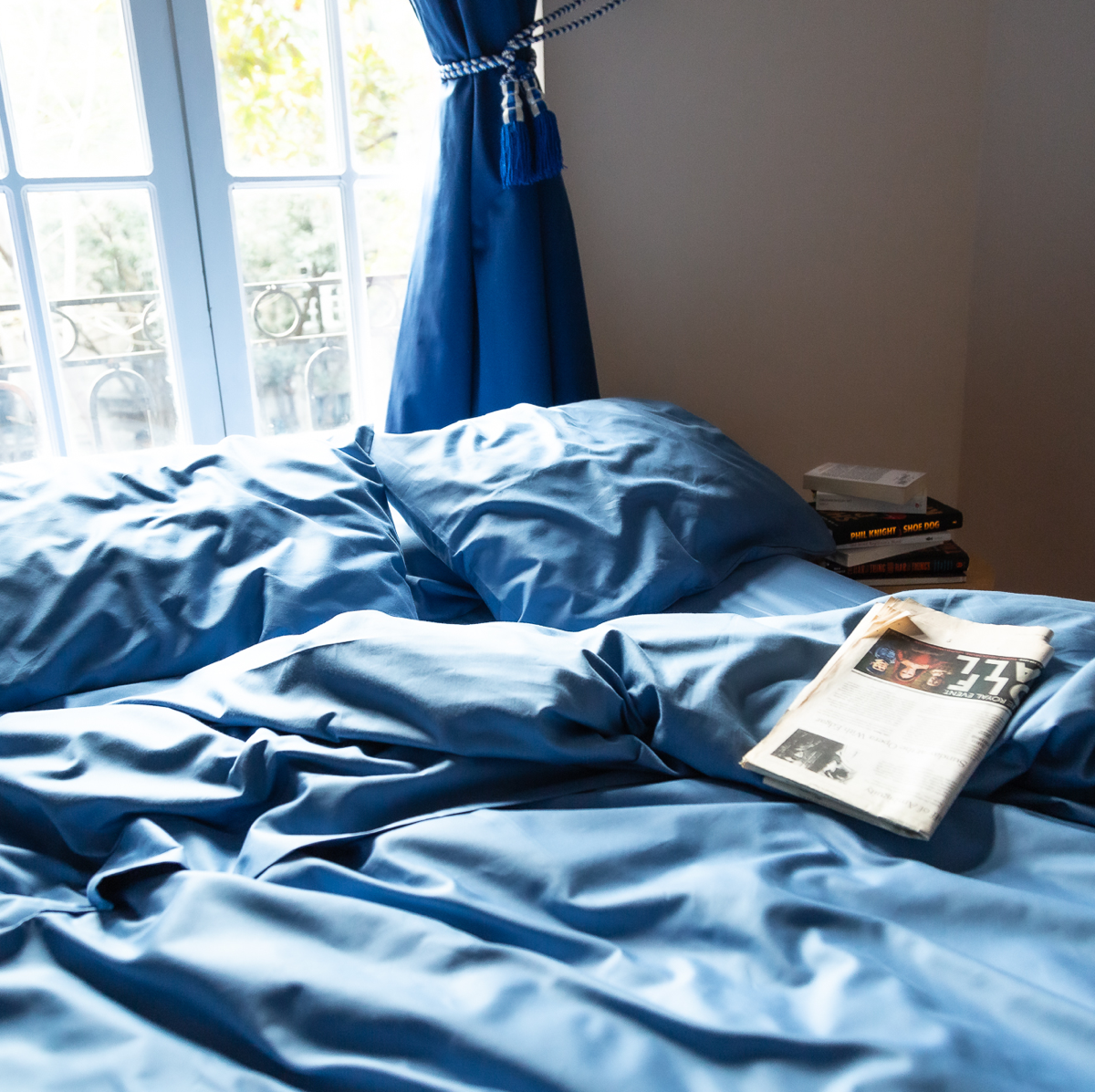 cama con juego basico de sabanas azul nuit y periodico